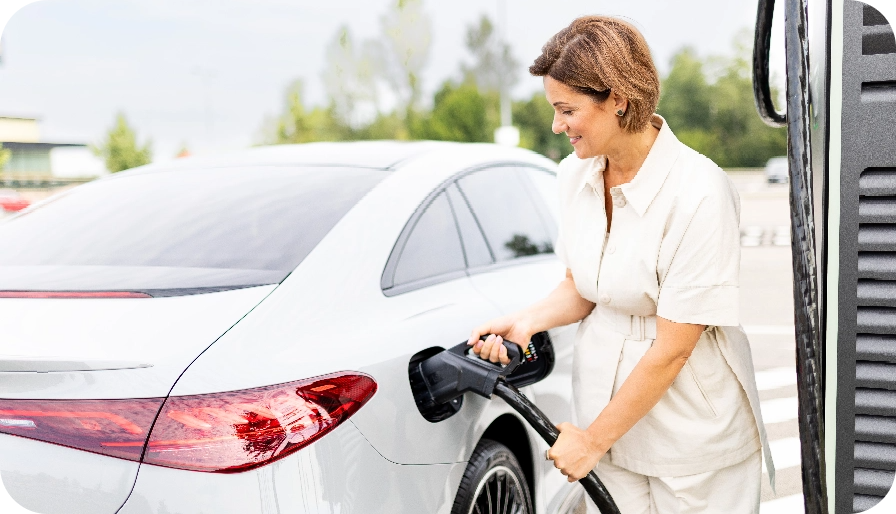Sieviete uzlādē savu elektroauto