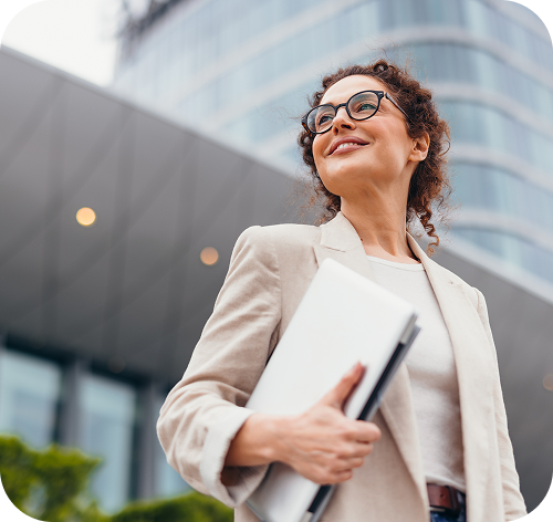 Smaidoša sieviete ar portatīvo datoru rokā.