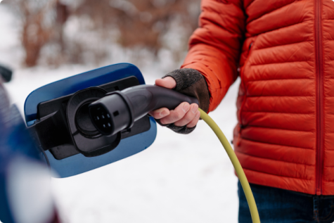 Vīrietis lādē savu elektroauto