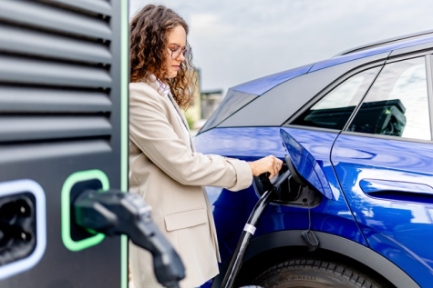 Sieviete uzlādē elektroauto “Ignitis ON” stacijā