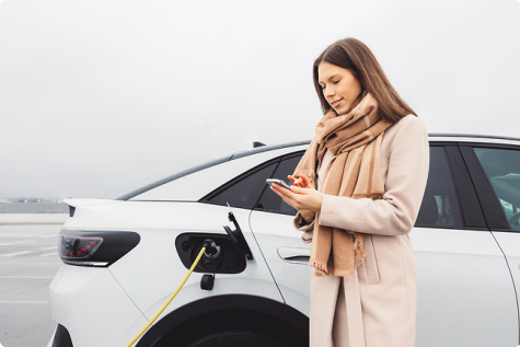 Sieviete uzlādē savu elektroauto