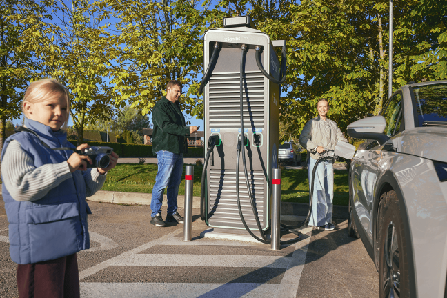Ģimene uzlādē elektroauto Ignitis ON uzlādes stacijā.