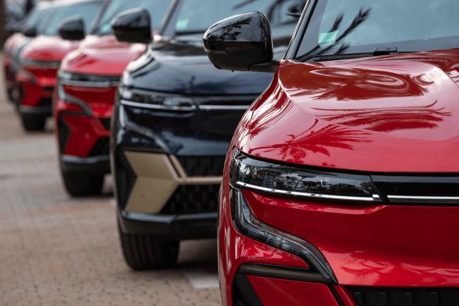 Krāsaini elektroauto stāv sarindoti rindā.