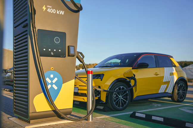 Dzeltens elektroauto tiek uzlādēts īpaši ātrajā Ignitis ON uzlādes stacijā.